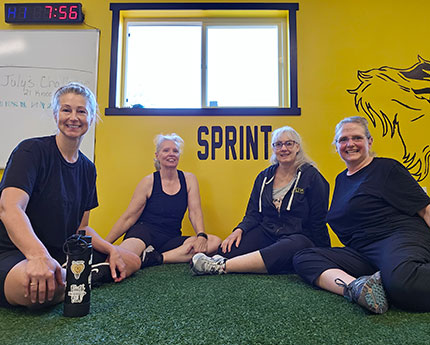 four people sitting on floor of gym